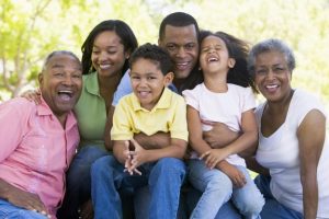 Three happy generations of a Black family are grouped together. Transferring property to family members may be a bad idea, depending on several factors.